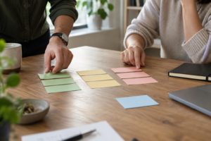 Illustration générée : deux personnes trient des cartes de priorités sur une table ; scène fictive, sans représentation d’un client.